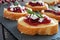 Crostini with cranberry sauce, cheese, rosemary close up on slate