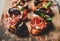 Crostini with prosciutto, goat cheese and grilled figs on board