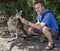 Crouching man feeds a beautiful very hungry kangaroo, Australia