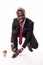 Crouching young african businessman tying shoe laces looking at camera. Full body length portrait isolated over white studio