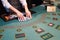 Croupier shuffling playing cards at poker table