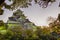 Crow Castle or Ujo Castle in Okayama City on the Asahi River in Japan With Traditional Maple Branches in The Frame