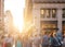 Crowd of anonymous people walking down the busy sidewalk on 23rd Street in Manhattan, New York City with bright light of sunset