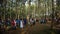 Crowd of anonymous people walking through forest jati trees