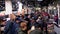 Crowd of buyers in a supermarket walks between rows of goods. Sellers stand behind the shelves