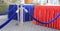 Crowd control barriers with blue velvet rope and reception tables covered with red and blue silk fringe