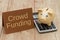 Crowd Funding, A golden piggy bank, card and calculator on wood