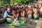 Crowd of Hindu pilgrims assemble at bank of river and pray for late ancestors.