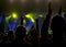 Crowd at music concert, people silhouettes backlit by stage lights.