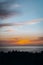 A crowd of people admire the sunset on a cliff on the Pacific Ocean