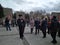 a crowd of people goes down the street to a rally with flags and posters a police officer keeps