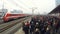 A crowd of people in an open air metro or train station