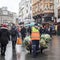 A crowd of people at Piccadilly Circus. Casino. Garbage collector comes with a garbage cart