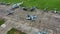 A crowd of people push and move a combat gray blue fighter plane to a parking spot at the airfield against airfield