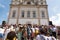 a crowd of people on steps outside a church with large tower