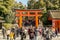 Crowd of peoples and tourists front of a big red Torii gate of Fushimi Inari Shrine.