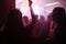 Crowd on the rock show. Silhouettes of people on the concert. Fans dancing and raising hands in front of the stage