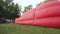 Crowd of spectators watching big balloon filling with hot air before flight