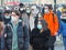 Crowd of teenagers walking downtown wearing protective masks during pandemic alert