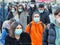 Crowd of teenagers walking downtown wearing protective masks during pandemic alert