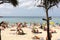 Crowd tourists, sunbed and umbrellas on the beach