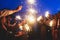 A crowd of young happy people with bengal fire sparklers in their hands during birthday celebration