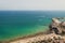 Crowded beach with a blue Mediterranean sea seen from a hill