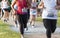 Crowded group of runners racing a 5K around Belmont Lake