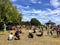 A crowded park of people enjoying the sunshine and the local market