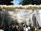 Crowded people looking white flower arrangement