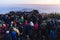 Crowded people are waiting for the first light in the dawn of new year`s day with mountain and fog in background at Tiger Hill.