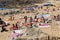 Crowded rocky beach in Porto, Portugal. People sunbathing on a sand