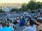 Crowds of tourists sit on Sacre Coeur stairs and view skyline of Paris from Montmartre