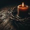 The crown of thorns worn by Jesus, illuminated by a single candle on wooden surface