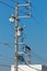 Crows on electrical wires against blue sky.