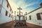 Crucified Jesus on a cross and street lights of historical andalusian city