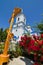 Crucifix cross in churchyard of Dormition of the Mother of God russian Orthodox church, red roses orchard