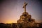 crucifix in the foreground under a night sky with stars.