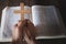 The crucifix in human hands rests on the Bible. Concepts for the study of Christians, Christianity, Catholicism, God, Heaven,