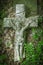 The crucifixion of Jesus Christ. Very old and ancient stone destroyed statue in the grass. Vertival image