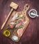 Crude appetizing chicken breast with rosemary, butter and salt on vintage cutting board hammer for meat Healthy food on woo