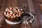 The crude hazelnut in translucent plate with a rope on a table with a wooden background.