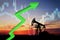 Crude mining concept and graph of falling oil prices on the trading exchange. Crude oil pump jack at oilfield on sunset backround