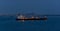 Crude oil tanker with navigation lights anchored in front of an oil storage terminal  at night