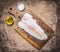 Crude Pangasius on a cutting board with butter and salt wooden rustic background top view close up