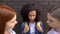 Cruel schoolgirls looking each other, scared black classmate background, abuse