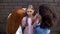 Cruel schoolgirls pushing younger teenager against wall, psychological pressure