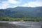 A cruise boat touring the small river close to Bertioga Brazil on a sunny day before the hills with green woods, wild