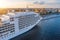 Cruise liner moored at the embankment in the waters of the river in the evening at sunset. Aerial top front side view