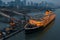 Cruise ship docked adjacent to a pier, with towering skyscrapers in the background in Wuhan, China